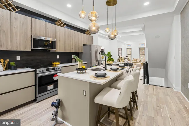 a kitchen with stainless steel appliances granite countertop a stove and a wooden floors