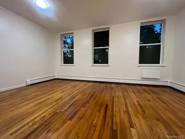 a view of a room with wooden floor and window