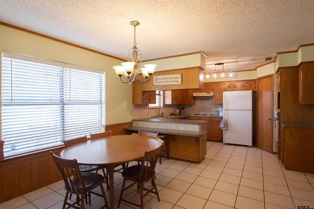 a kitchen with a table chairs and refrigerator