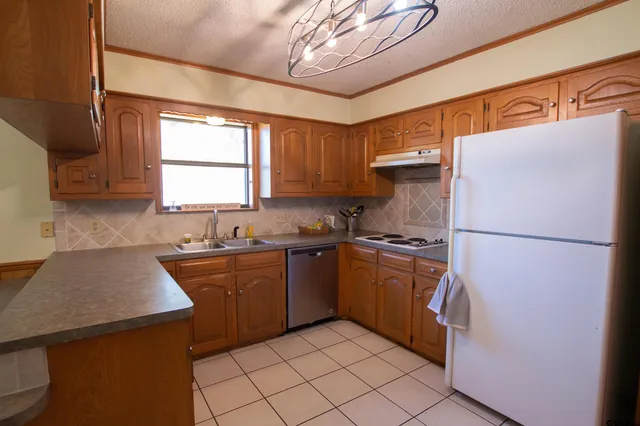 a kitchen with stainless steel appliances granite countertop a refrigerator stove sink and dishwasher