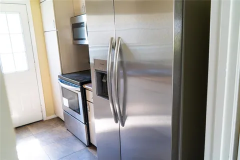 a metallic refrigerator freezer sitting in a kitchen
