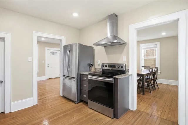 a kitchen with wooden floors and stainless steel appliances