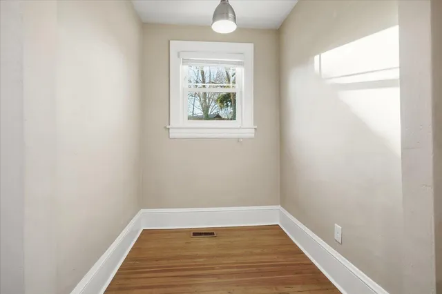 a view of a room with wooden floor and window