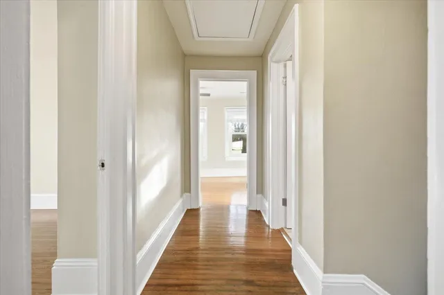 a view of a hallway with wooden floor