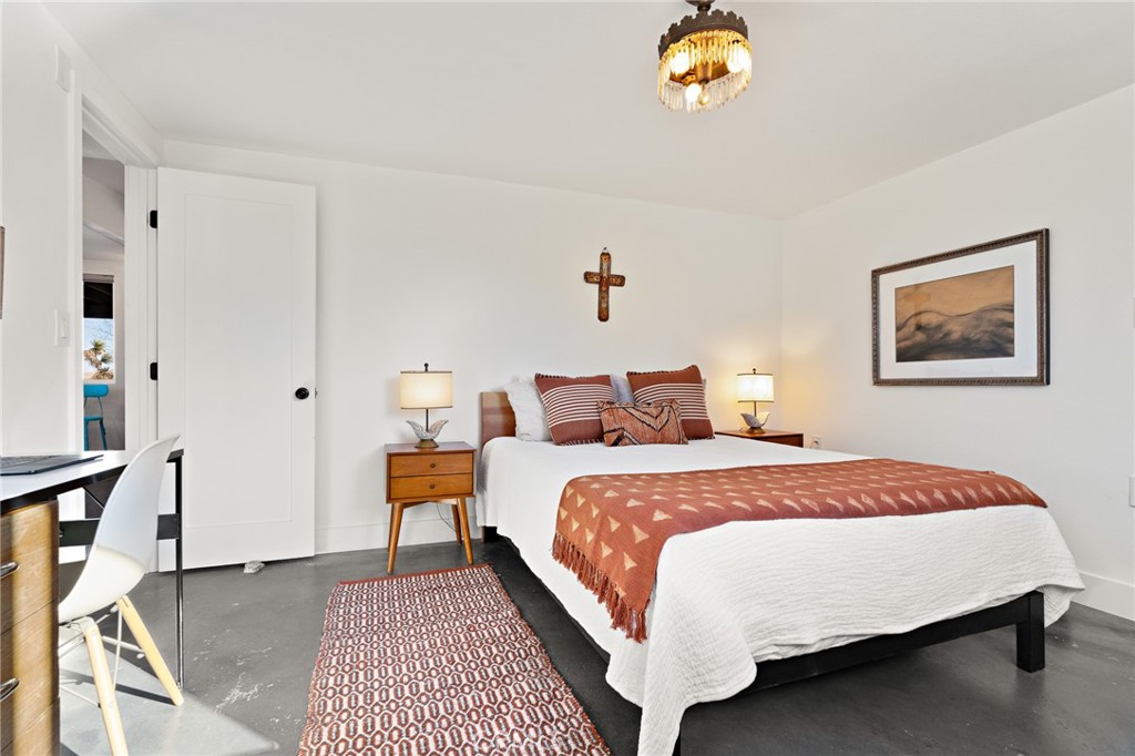 4212 Oneill Road Joshua Tree, CA 92252 - Photo 24 of 60 a bedroom with a bed and a chandelier