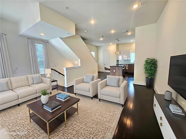 a living room with furniture a flat screen tv and a large window