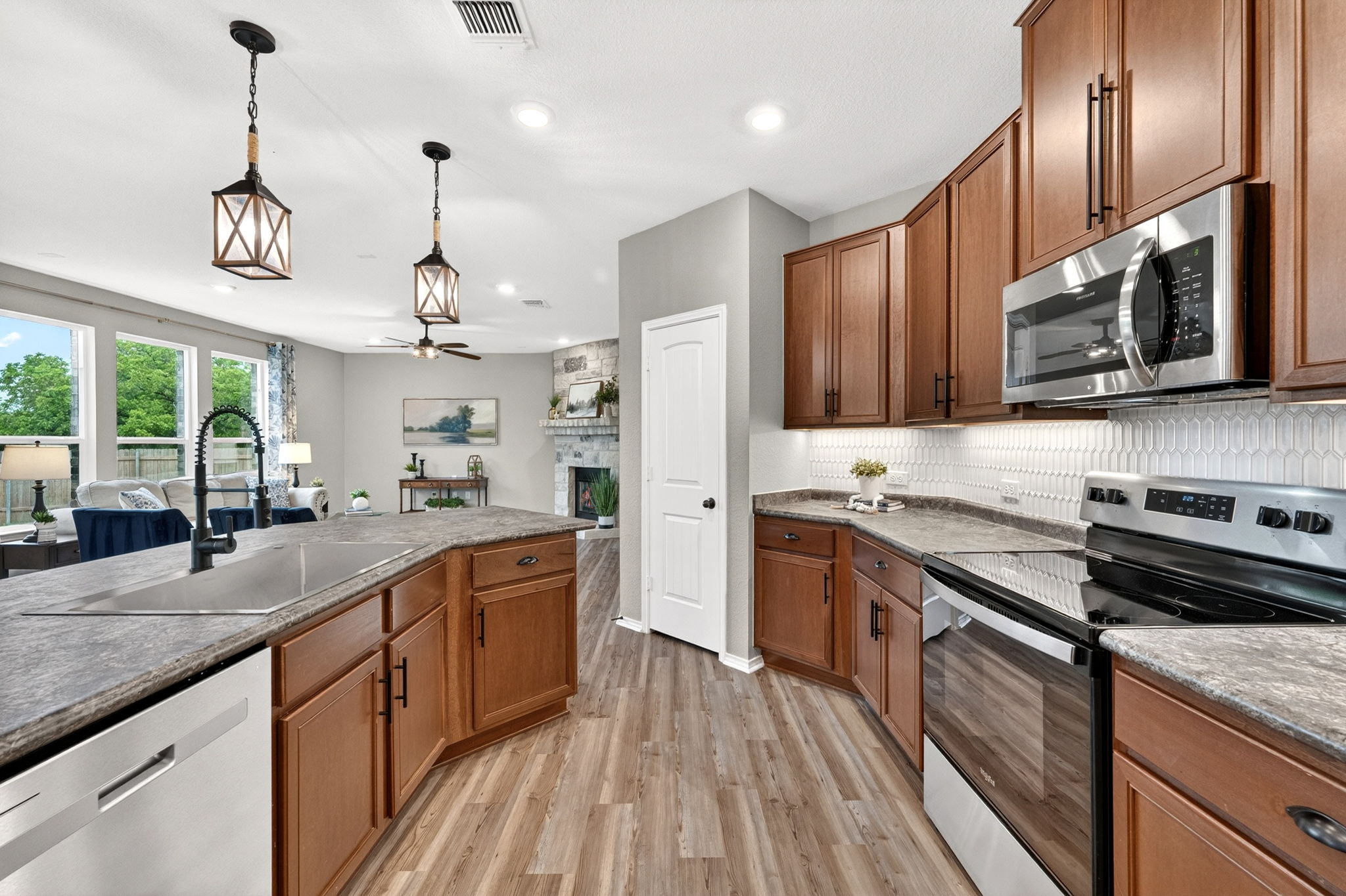 326 Linden Street Bastrop, TX 78602 - Photo 25 of 39 Large kitchen island with a deep single-bowl sink. Beautiful tile backsplash, undercabinet LED lighting & stainless steel appliances.