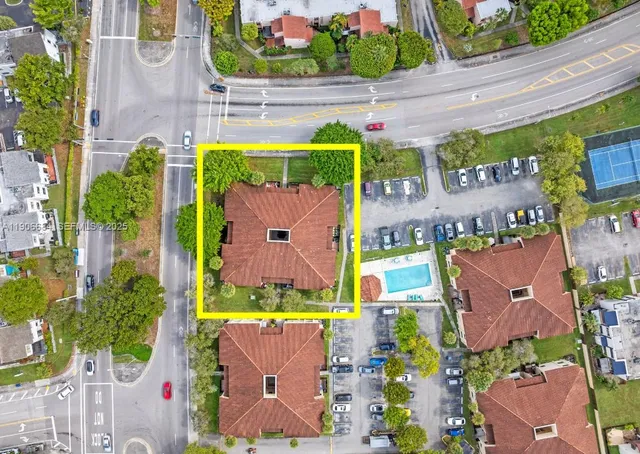 an aerial view of residential houses with outdoor space and parking