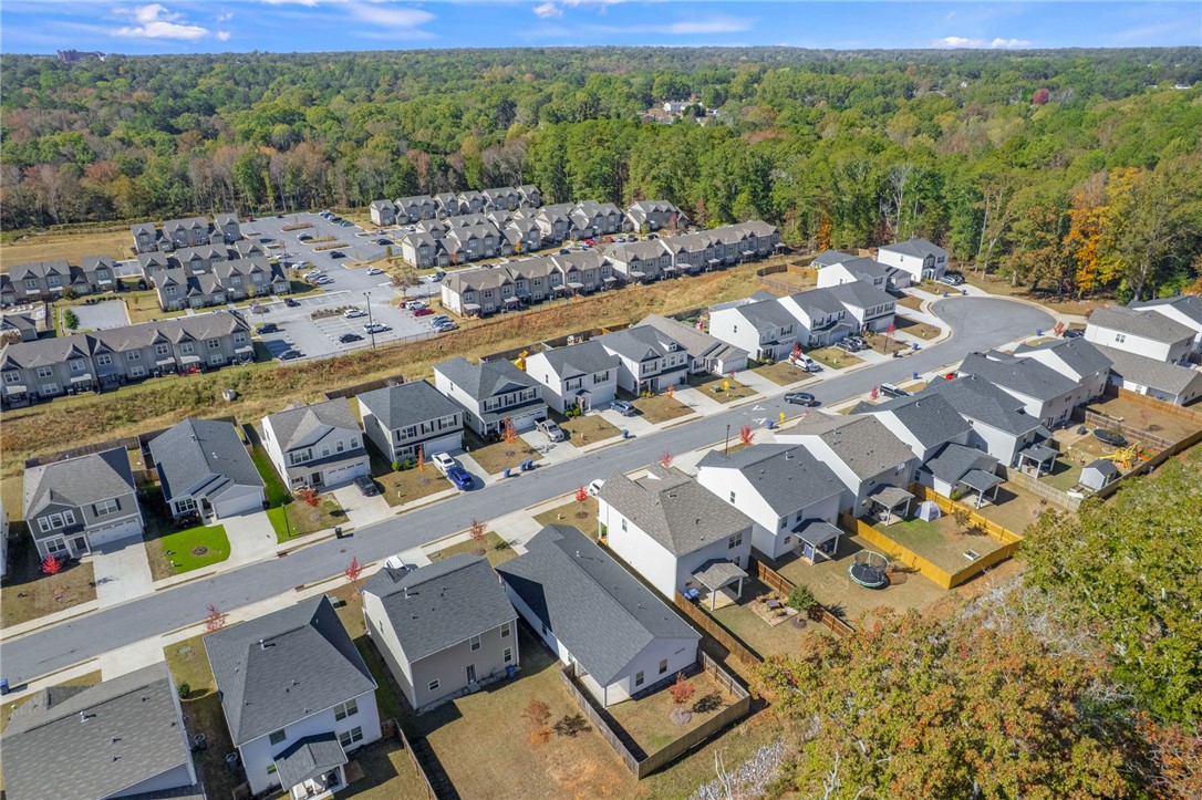 24 Chalet Court Anderson, SC 29621 - Photo 36 of 39 An aerial view of a vibrant residential community nestled beside a lush, expansive wooded area.