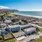 an aerial view of a city with lots of residential buildings and mountain view in back