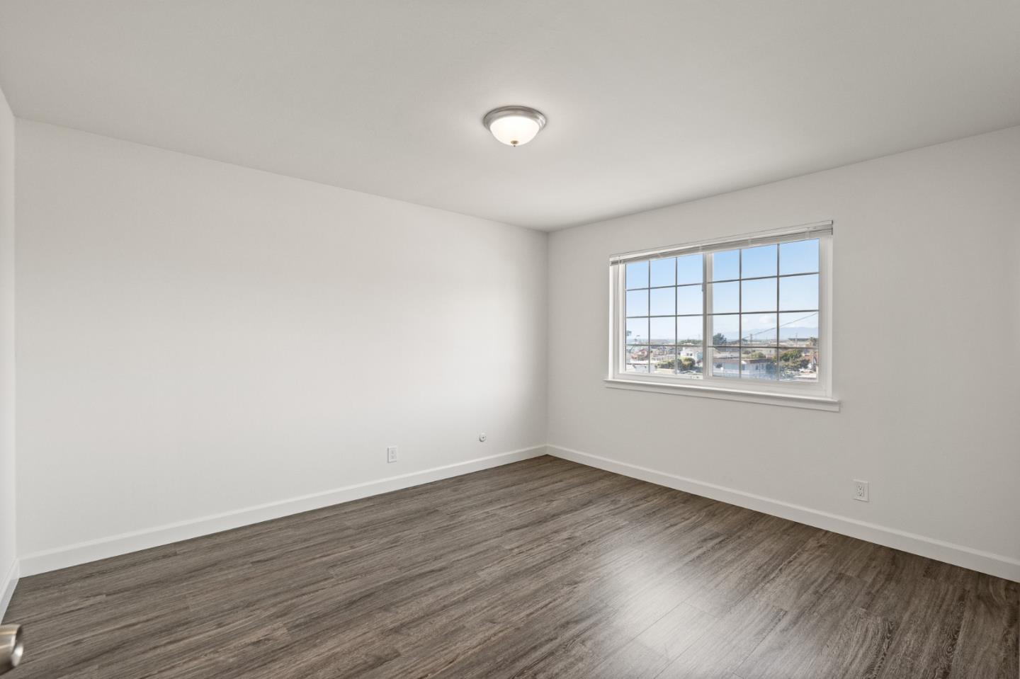 127 Hilton Way Pacifica, CA 94044 - Photo 15 of 18 an empty room with wooden floor and windows