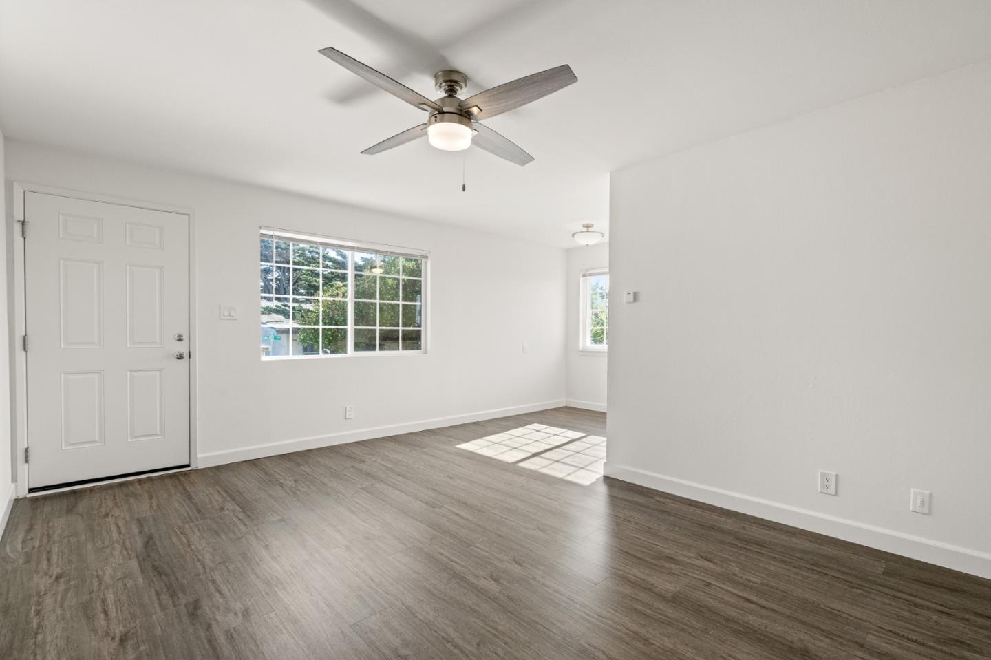 127 Hilton Way Pacifica, CA 94044 - Photo 9 of 18 an empty room with wooden floor fan and windows