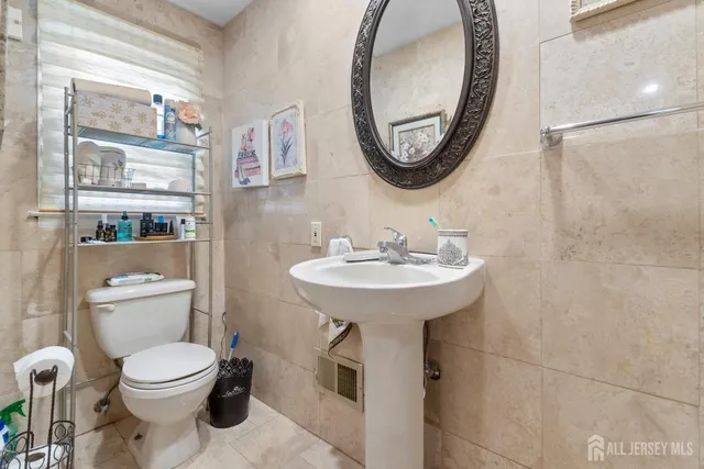 a bathroom with a toilet sink and mirror