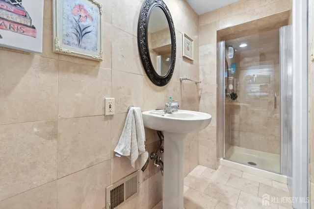 a bathroom with a sink mirror and a shower