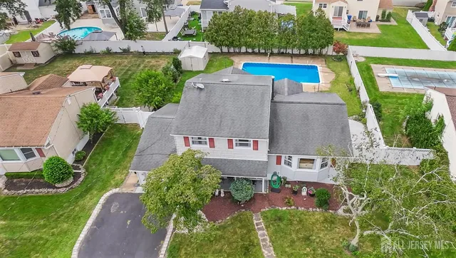 an aerial view of a house with a garden and lake view