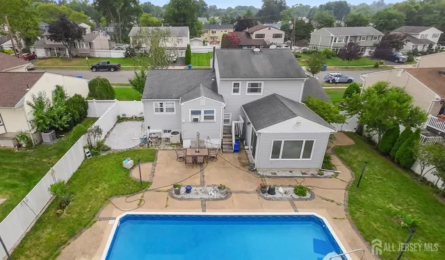 a view of swimming pool with outdoor seating and house in the background