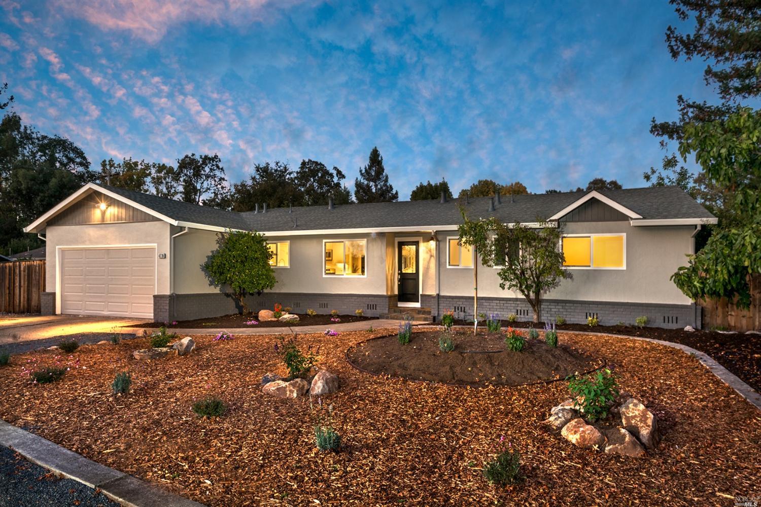 a front view of house with yard and trees in the background