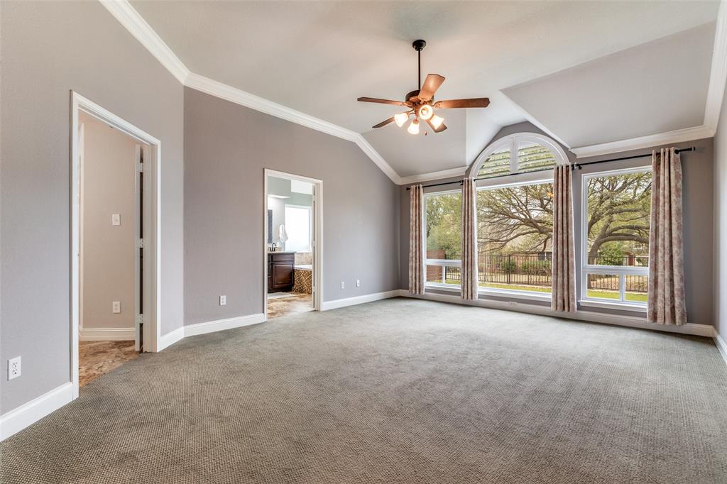 2704 Wind Ridge McKinney, TX 75072 - Photo 16 of 35 Primary bedroom with crown molding, lofted ceiling, new carpet and ceiling fan (new windows)