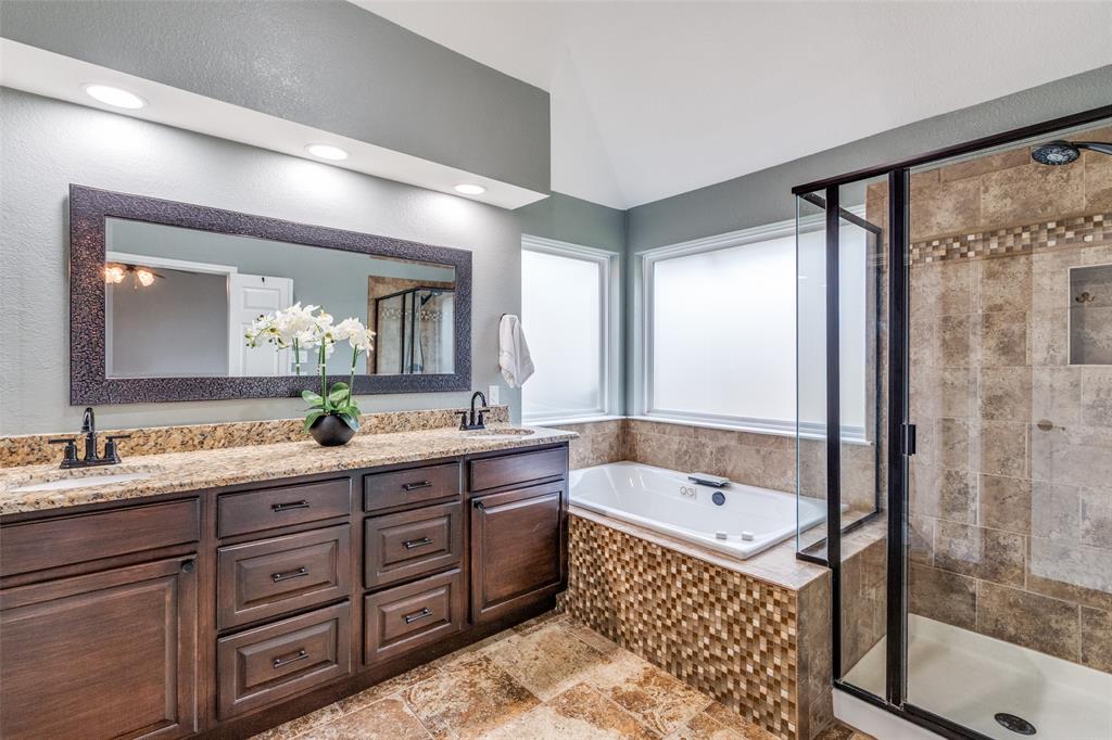 2704 Wind Ridge McKinney, TX 75072 - Photo 18 of 35 Primary bathroom with high ceiling, double vanity, a garden tub, large shower, and stone tile floors. (Newly stained cabinets)