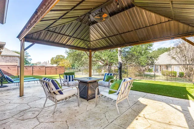 a view of patio with table and chairs under an umbrella