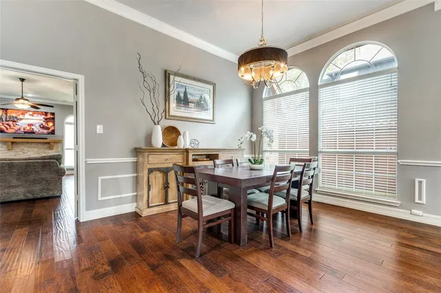 a view of a dining room with furniture a chandelier and wooden floor
