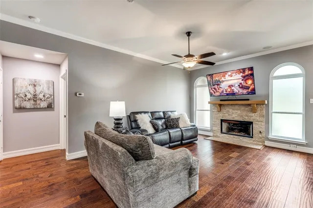 a living room with furniture a fireplace and wooden floor