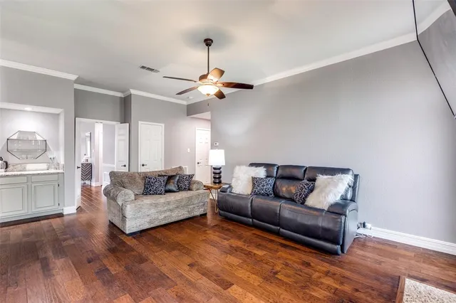 a living room with furniture and a ceiling fan