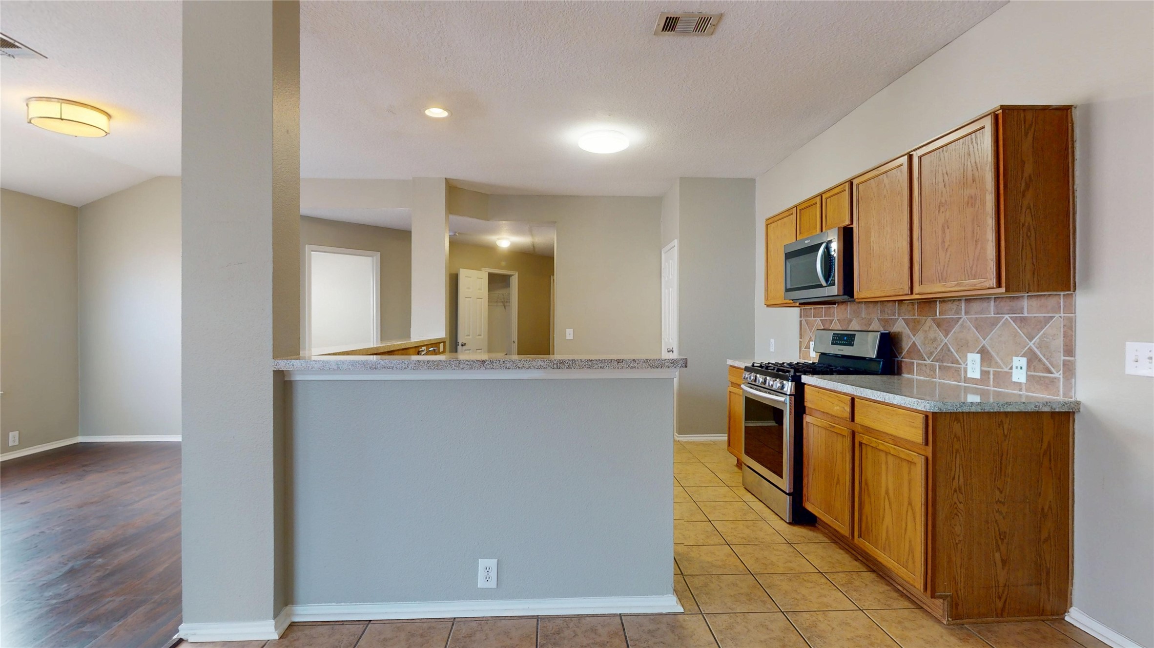 6007 Baldwin Elm Street Richmond, TX 77407 - Photo 11 of 45 a kitchen with stainless steel appliances granite countertop a stove a sink and a refrigerator