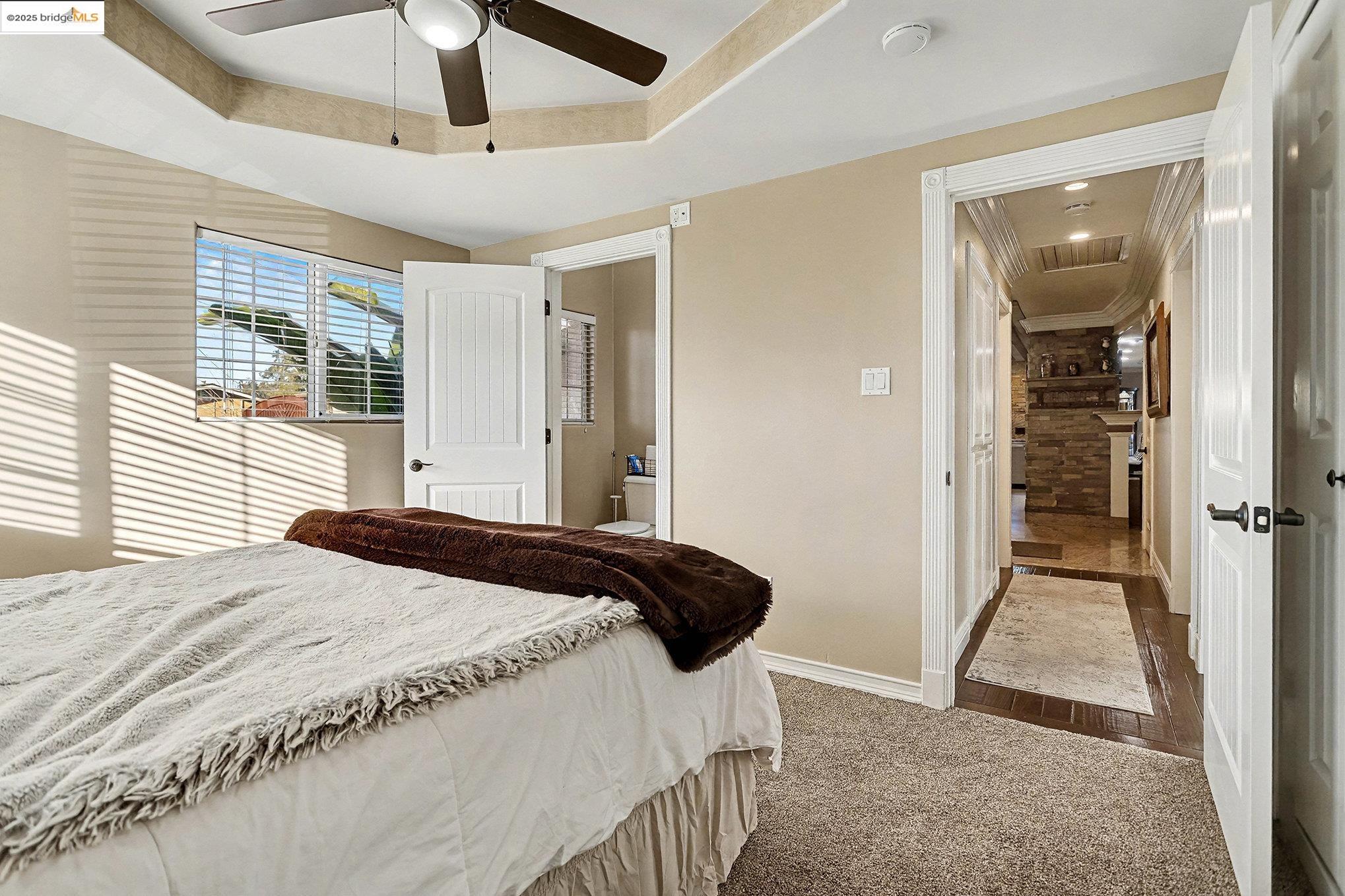 3614 Kay Court Fremont, CA 94538 - Photo 17 of 35 Carpeted bedroom featuring a tray ceiling, a ceiling fan, and connected bathroom