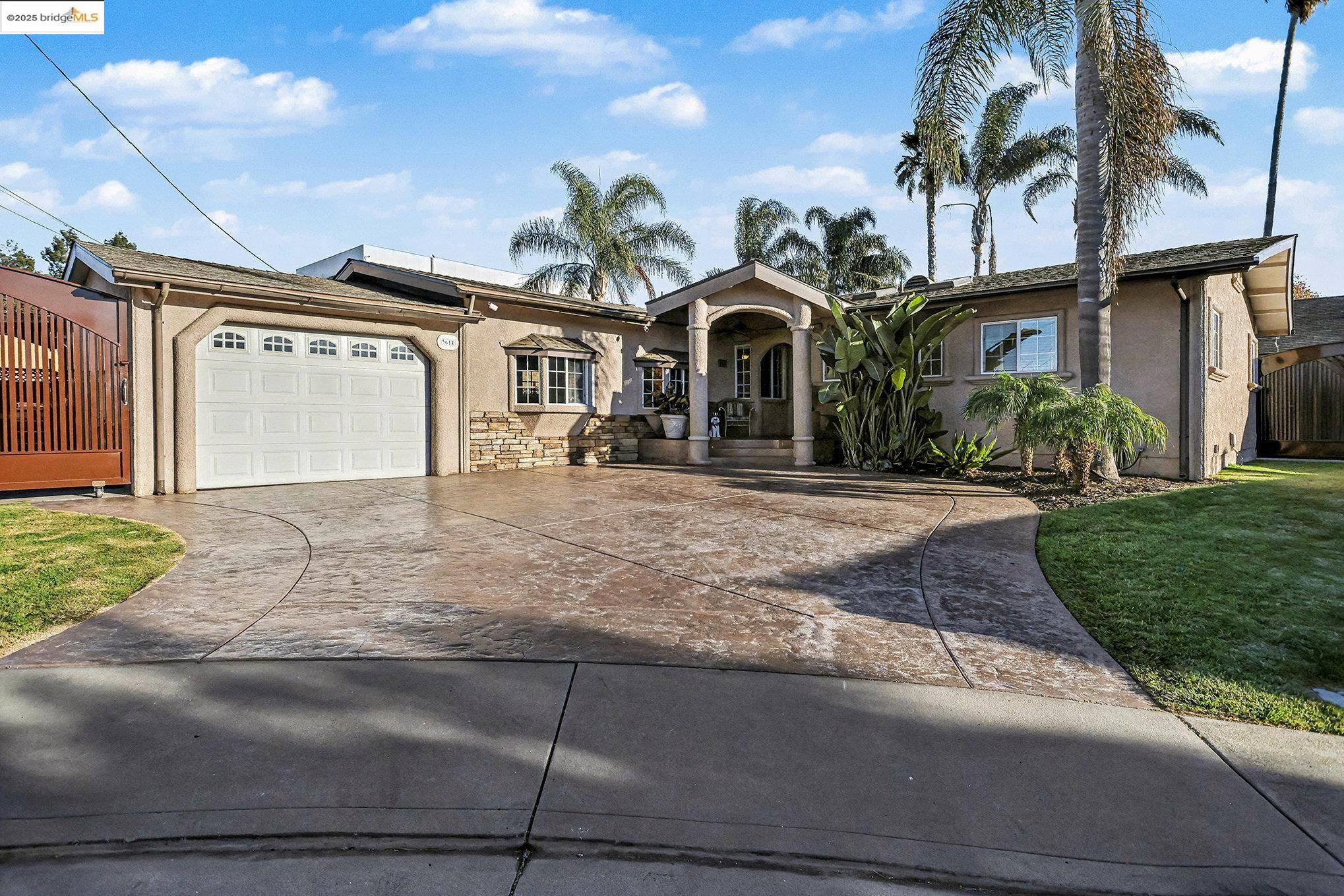 3614 Kay Court Fremont, CA 94538 - Photo 29 of 35 Single story home with stucco siding, concrete driveway, an attached garage, detached garage, stone siding, and roof mounted OWNED solar panels
