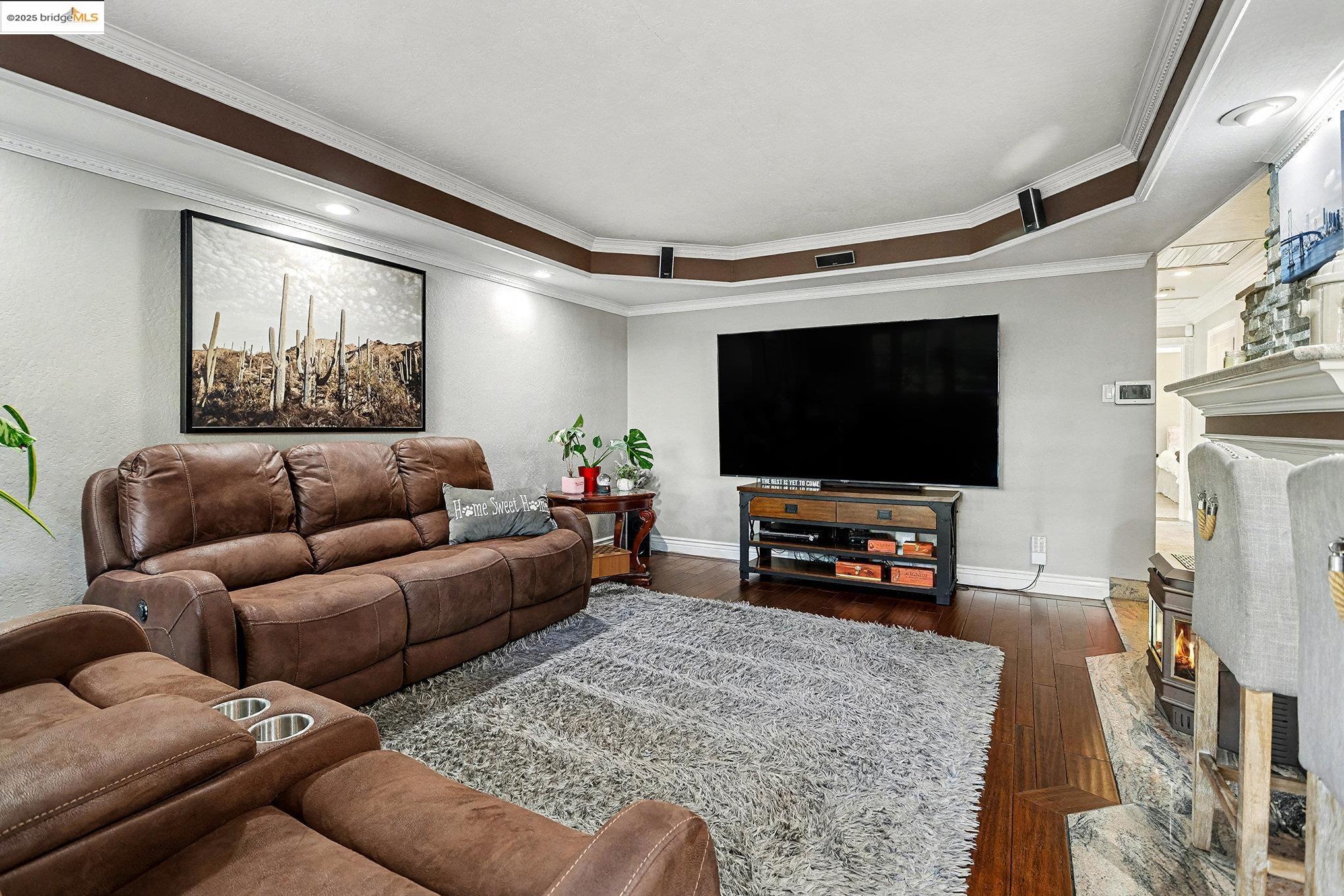3614 Kay Court Fremont, CA 94538 - Photo 7 of 35 Living area with bamboo flooring, a pellet fireplace, a tray ceiling, and crown molding