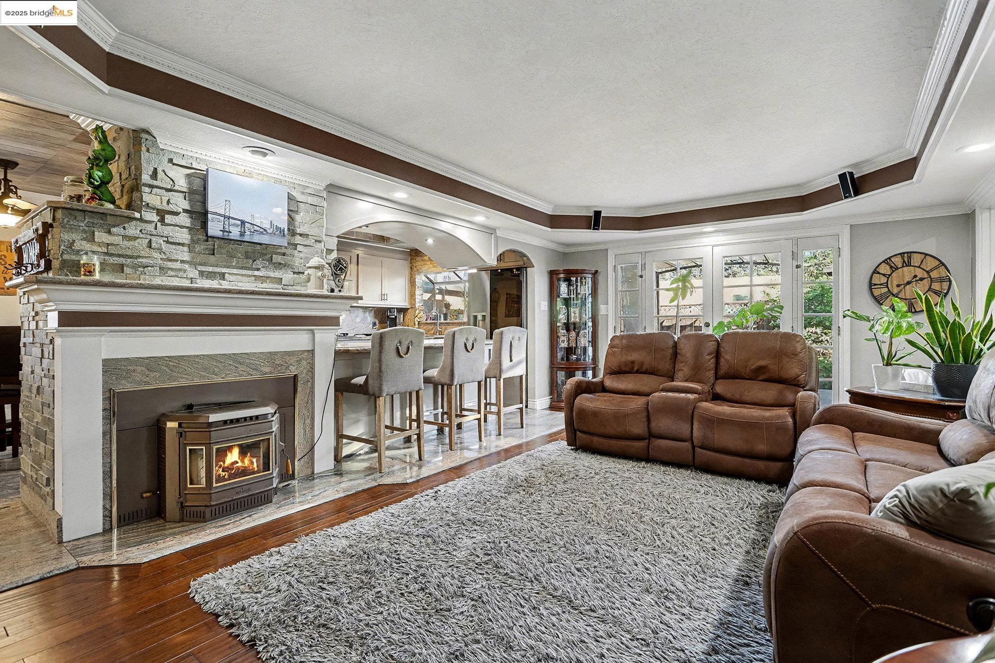 3614 Kay Court Fremont, CA 94538 - Photo 8 of 35 Living area featuring crown molding, bamboo floors, a tray ceiling, and a pellet fireplace