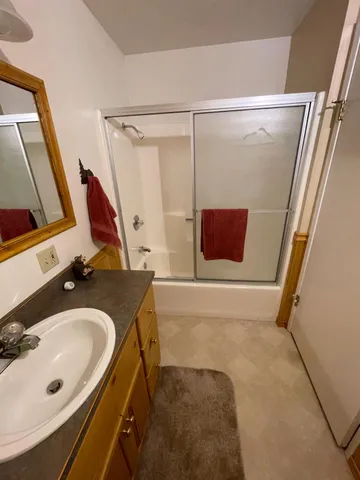 a bathroom with a sink and mirror with bathtub