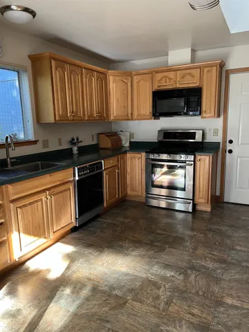 a kitchen with stainless steel appliances a stove a sink and a microwave