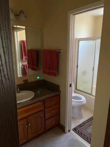 a bathroom with a sink a toilet and a mirror