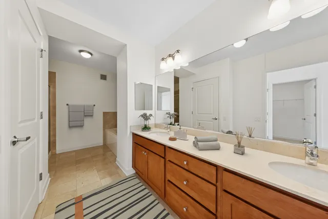 a bathroom with a double vanity sink mirror double and shower