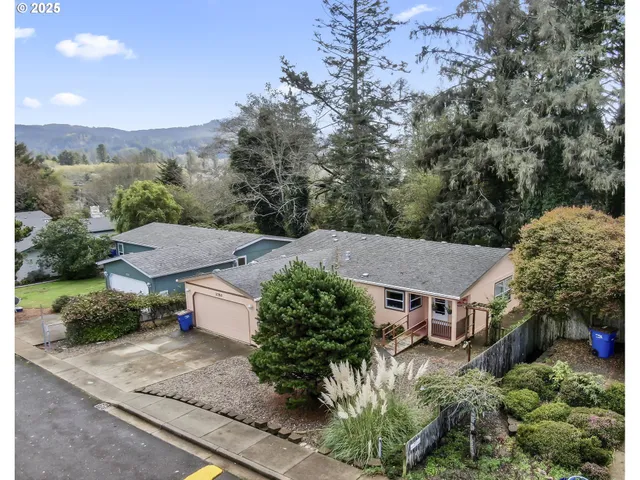 an aerial view of a house with yard and mountain view in back