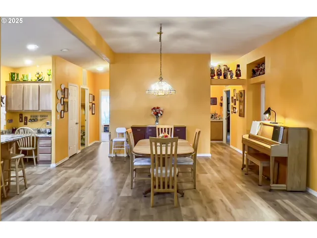 a kitchen with kitchen island granite countertop wooden floors cabinets and stainless steel appliances