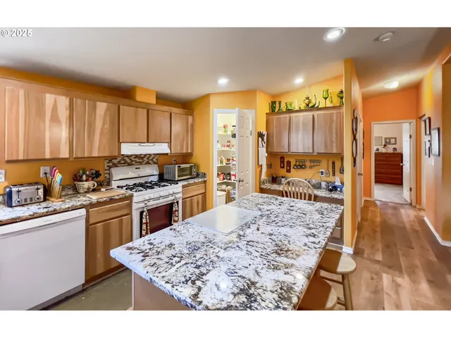 a kitchen with stainless steel appliances granite countertop a stove a sink and a refrigerator