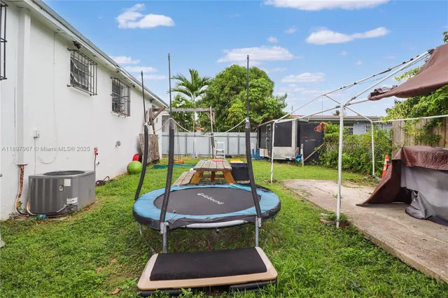 a view of a chair and table in backyard of the house