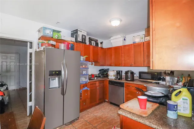 a kitchen with stainless steel appliances granite countertop a refrigerator a sink and a stove