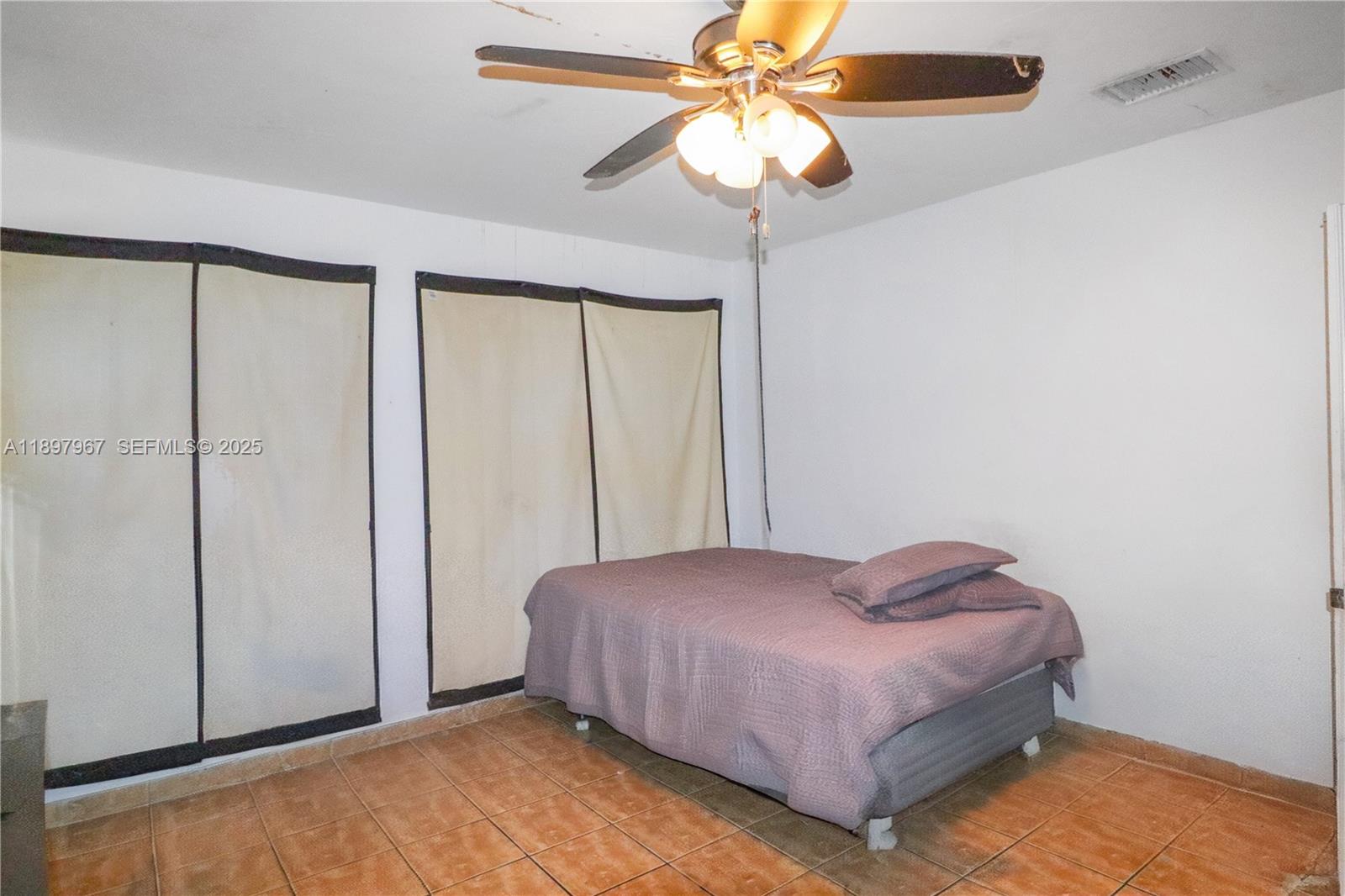 333 Southwest 30th Avenue Miami, FL 33135 - Photo 7 of 27 a bedroom with a bed and a chandelier