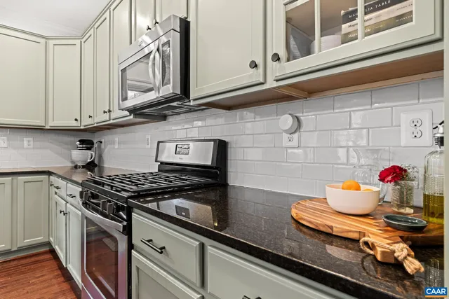 a kitchen with stainless steel appliances granite countertop a stove and cabinets