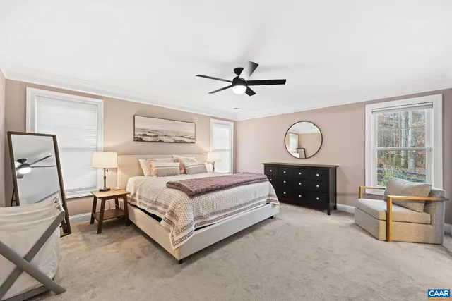 a spacious bedroom with a bed a chandelier and large window