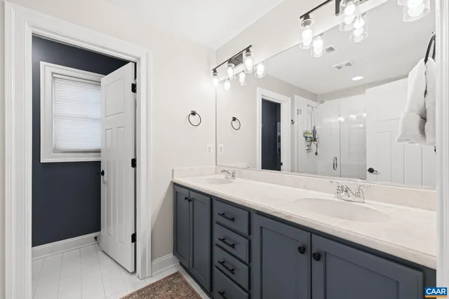a bathroom with a double vanity sink and a mirror