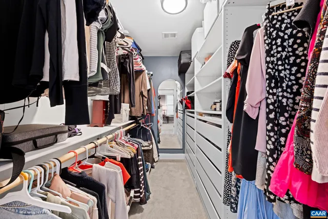 a view of walk in closet with clothes and shoes