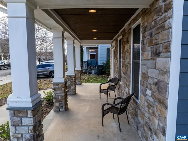 a view of a porch with chairs and potted plants