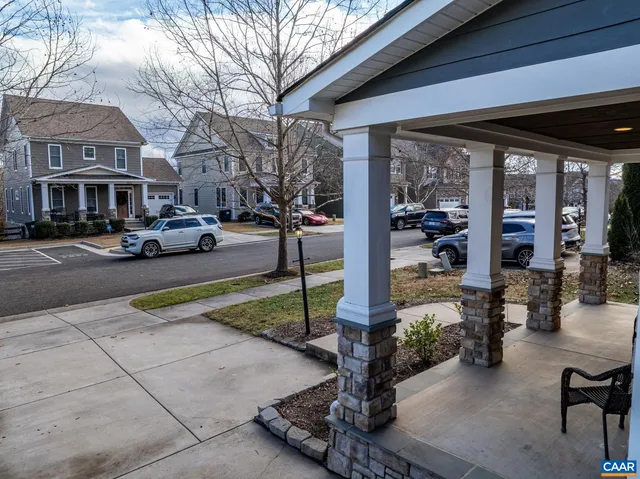 a front view of house with a barbeque and bench