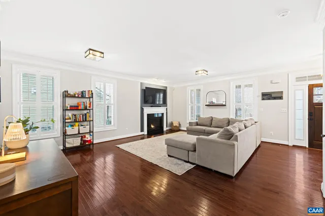 a living room with furniture and hard wood flooring