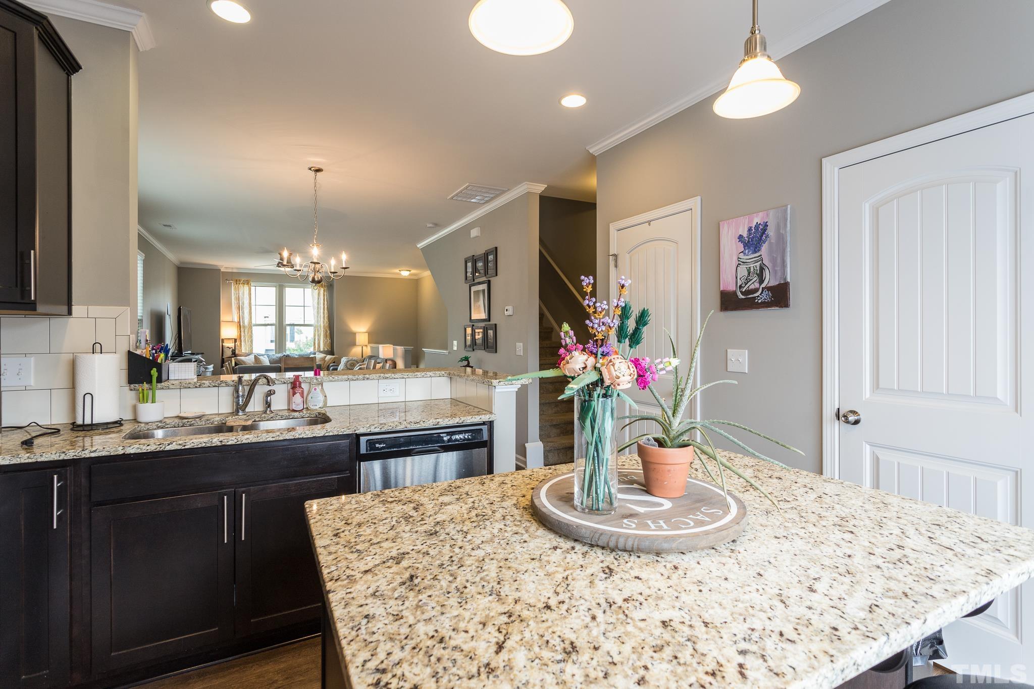 218 Irving Way Durham, NC 27703 - Photo 14 of 41 a kitchen with a kitchen island a sink stainless steel appliances and dining table